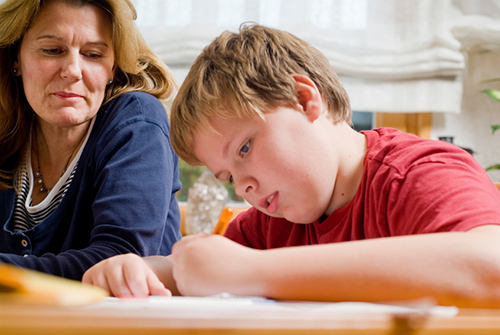 Preteen boy takes an assessment while a female counselor looks on